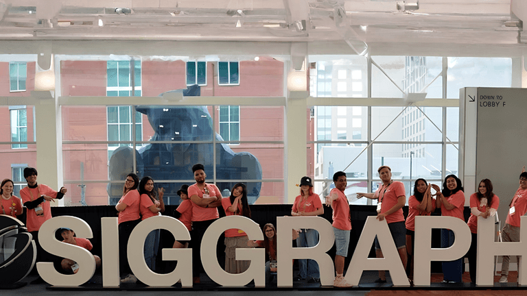 SIGGRAPH attendees posing behind large SIGGRAPH letters inside the Los Angeles Convention Center.