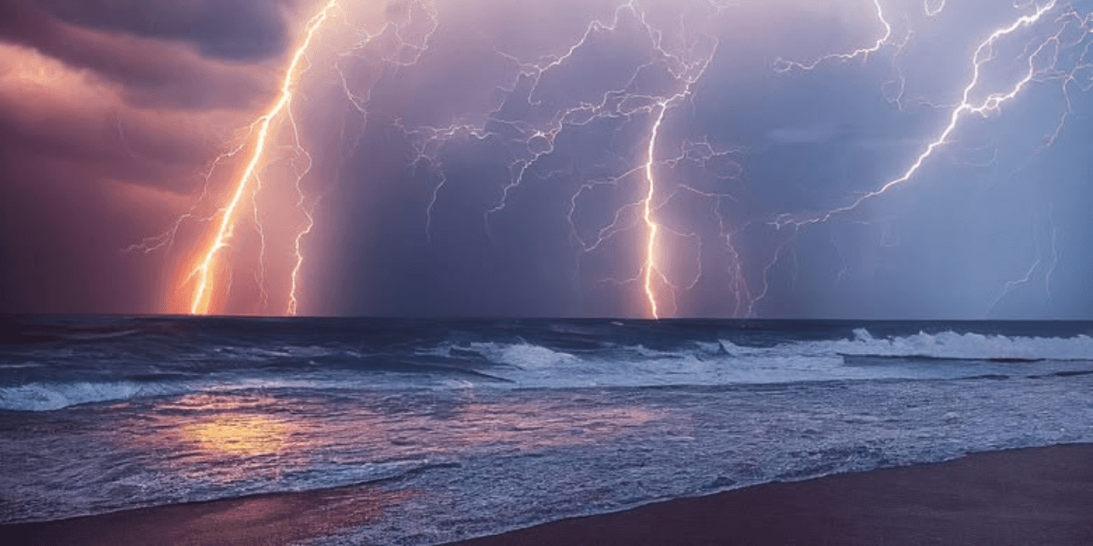 Dramatic lightning bolts illuminate dark stormy skies over turbulent ocean waves at dusk