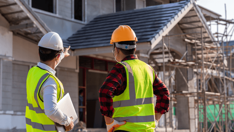 Two construction workers discussing a building project at a construction site