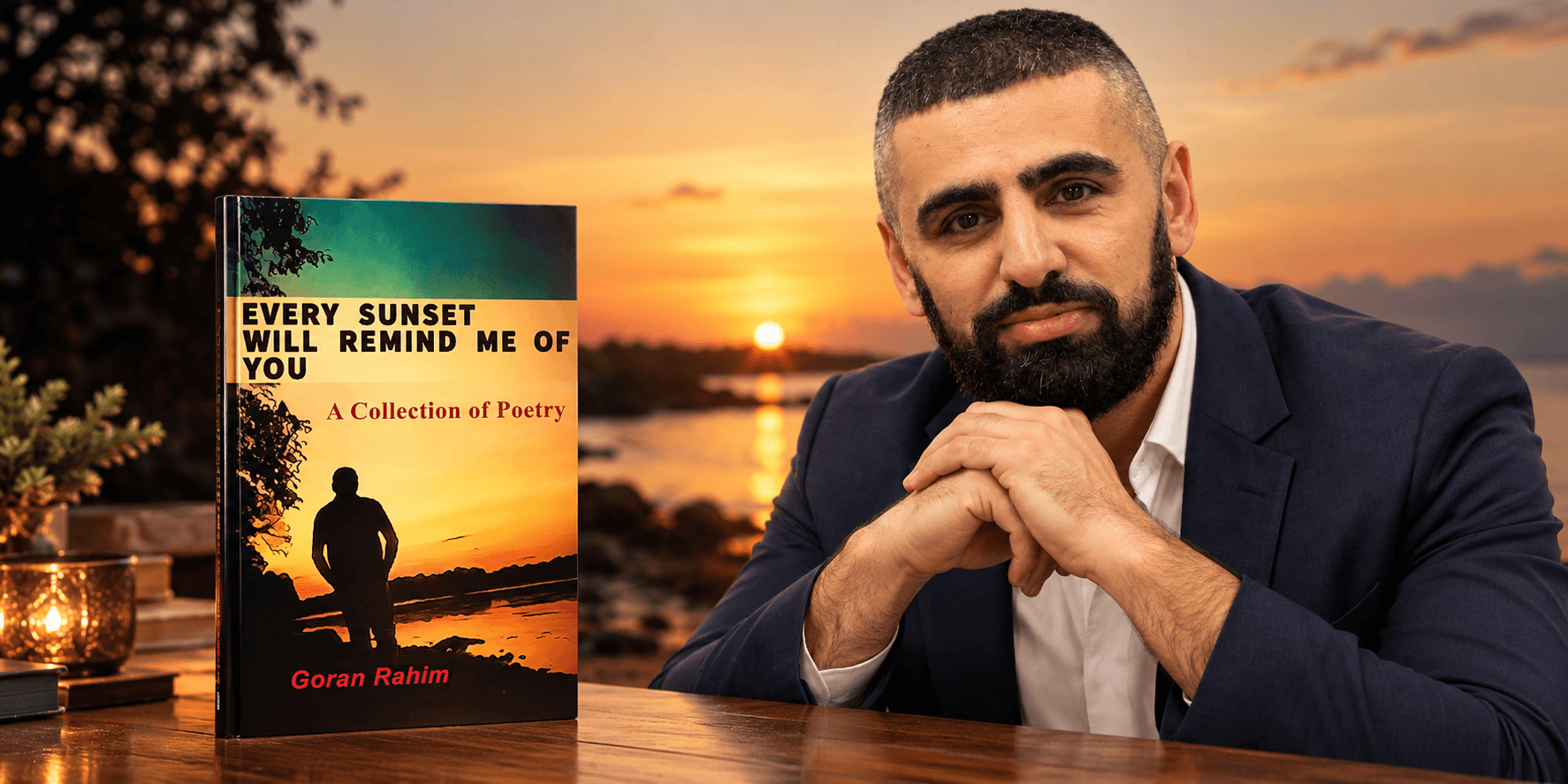 A man poses with his poetry collection against a sunset backdrop by the sea