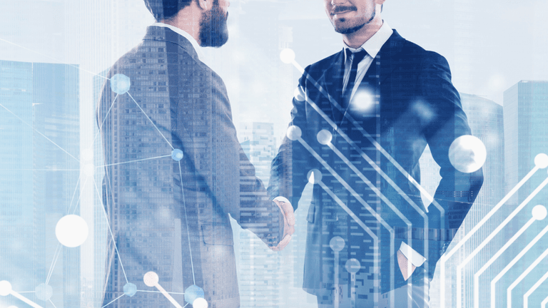 Two business professionals shaking hands with a digital city skyline overlay