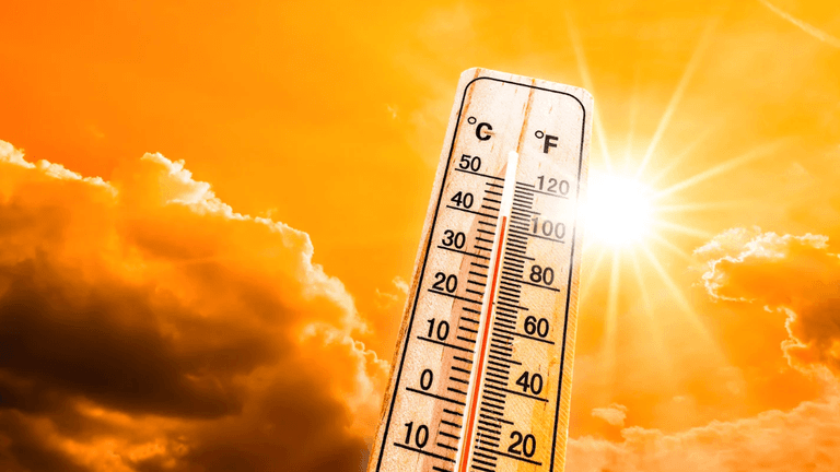 Thermometer showing high temperatures against a bright sun and cloudy sky backdrop