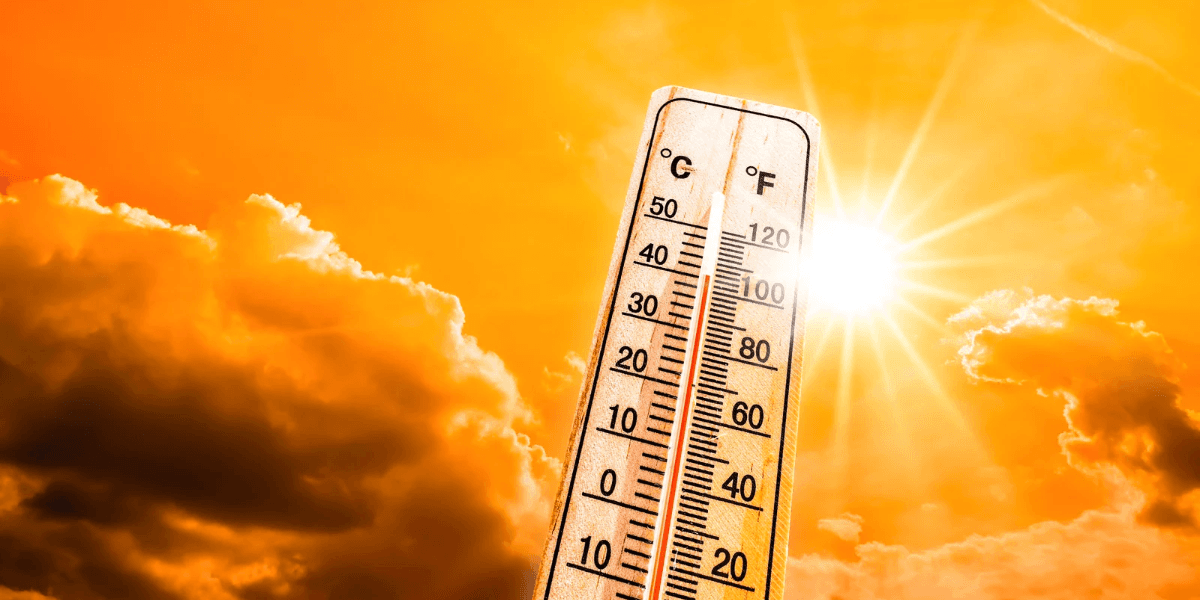 Thermometer showing high temperatures against a bright sun and cloudy sky backdrop