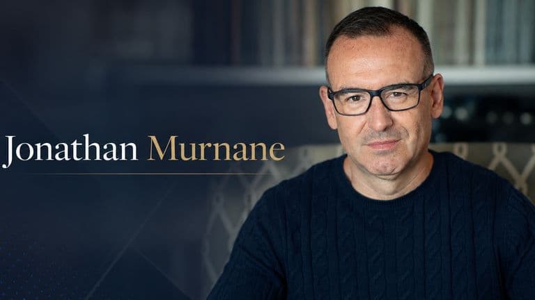 Jonathan Murnane portrait with name overlay in a dark library setting.