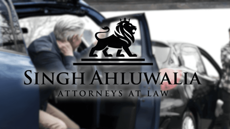 Car accident scene with injured person and lawyer's logo, Singh Ahluwalia Attorneys at Law, representing justice and recovery.