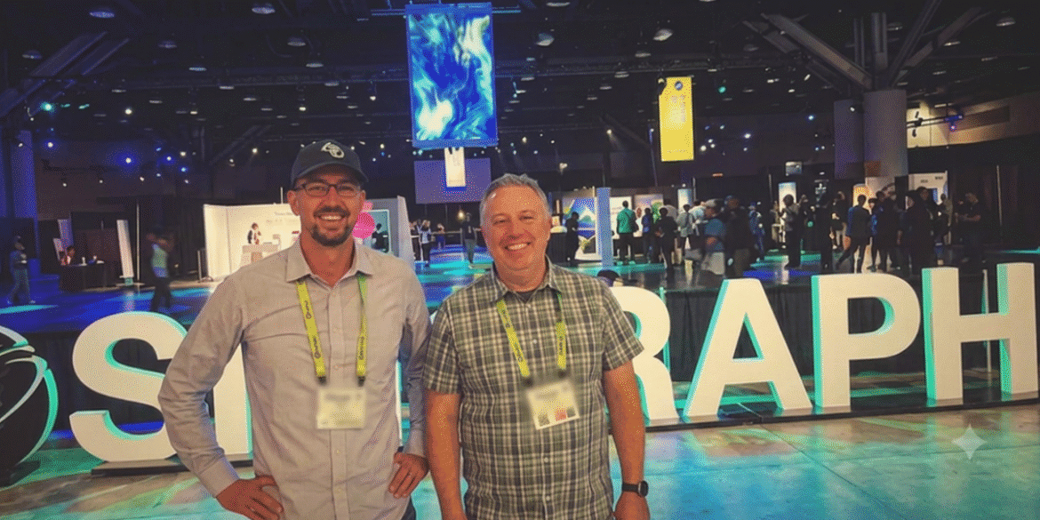 Two attendees standing in front of the illuminated SIGGRAPH sign at the SIGGRAPH 2026 conference in Los Angeles.